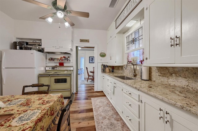 kitchen featuring sink, range, white cabinets, decorative backsplash, and white fridge