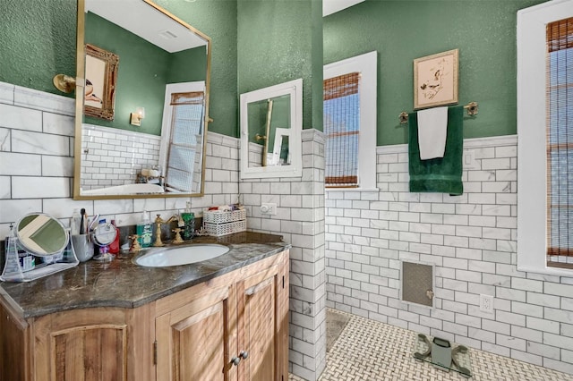 bathroom featuring vanity, tile patterned flooring, and tile walls