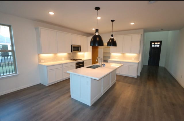 kitchen with white cabinetry, sink, a center island with sink, and dark wood-type flooring