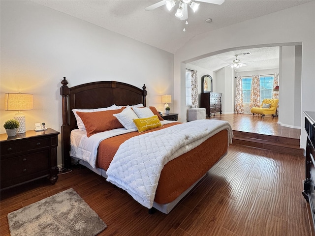 bedroom with dark wood-type flooring, ceiling fan, vaulted ceiling, and a textured ceiling