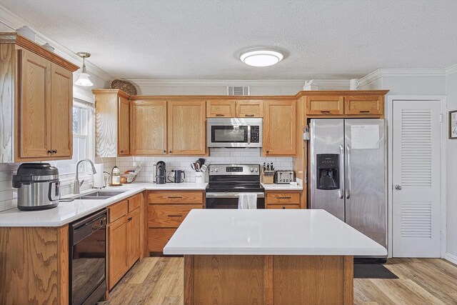 kitchen with sink, backsplash, a center island, stainless steel appliances, and crown molding