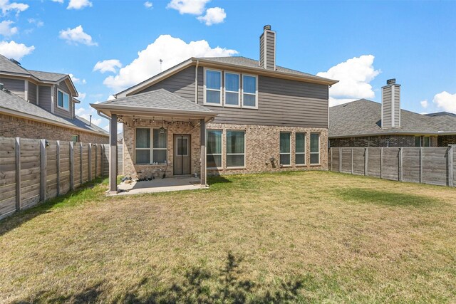 rear view of property with a patio and a yard