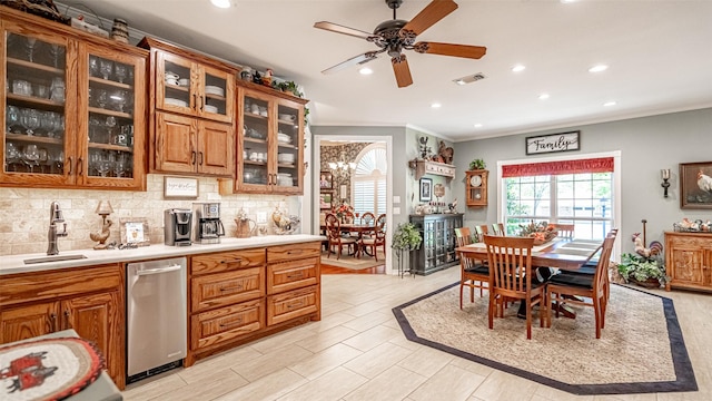 kitchen featuring sink, tasteful backsplash, ornamental molding, dishwasher, and ceiling fan