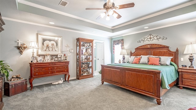 carpeted bedroom featuring ceiling fan, ornamental molding, and a tray ceiling