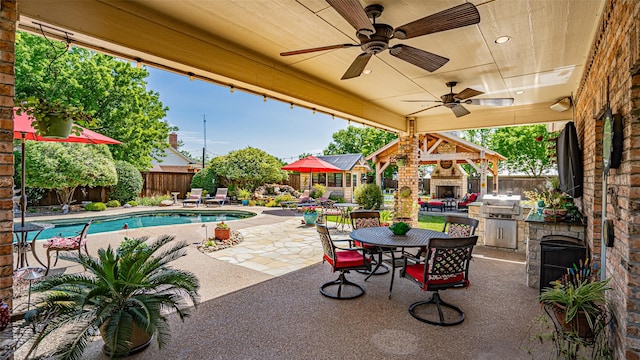 view of patio featuring ceiling fan, a grill, a fenced in pool, and an outdoor stone fireplace