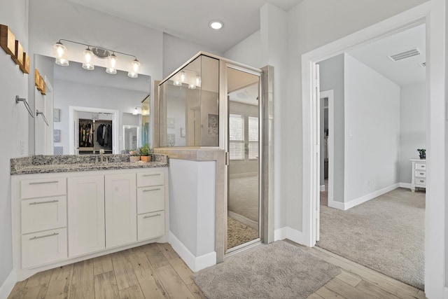 bathroom with vanity, hardwood / wood-style floors, and walk in shower