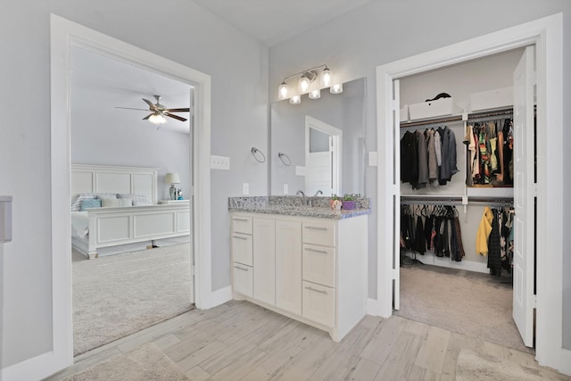 bathroom featuring ceiling fan, wood-type flooring, and vanity