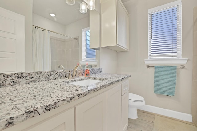 bathroom with vanity, a healthy amount of sunlight, tile patterned floors, and toilet