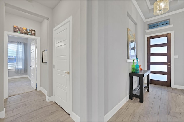 foyer featuring crown molding and light wood-type flooring