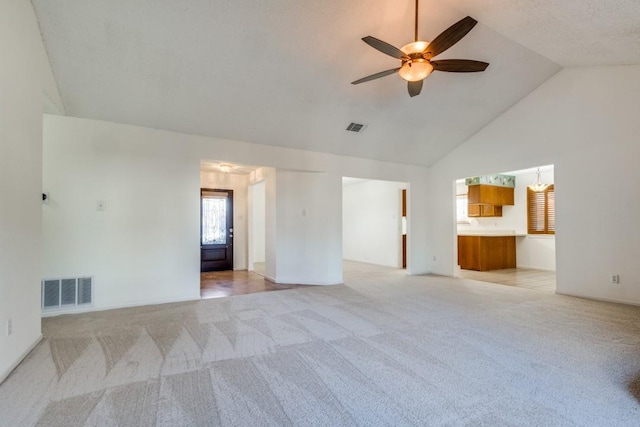 spare room with vaulted ceiling, light colored carpet, and ceiling fan