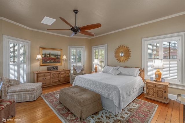 bedroom featuring ceiling fan, ornamental molding, light hardwood / wood-style floors, and multiple windows