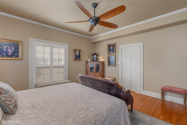 bedroom featuring hardwood / wood-style flooring, crown molding, and ceiling fan