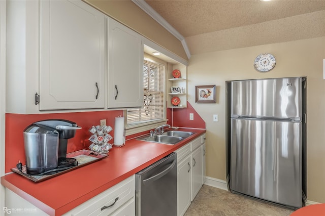 kitchen featuring lofted ceiling, sink, white cabinetry, a textured ceiling, and stainless steel appliances