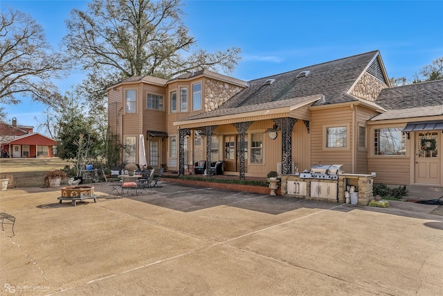 view of front of house with an outdoor kitchen and a patio area