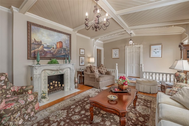 living room featuring vaulted ceiling with beams, crown molding, wood ceiling, a high end fireplace, and light hardwood / wood-style floors