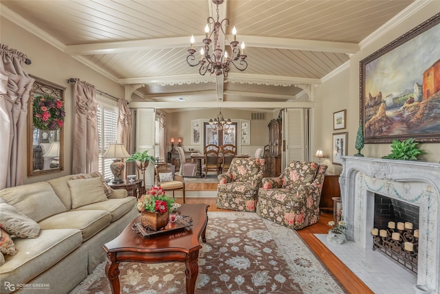 living room with beam ceiling, light wood-type flooring, a fireplace, and a chandelier