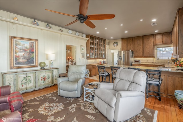 living room featuring sink, hardwood / wood-style floors, and ceiling fan