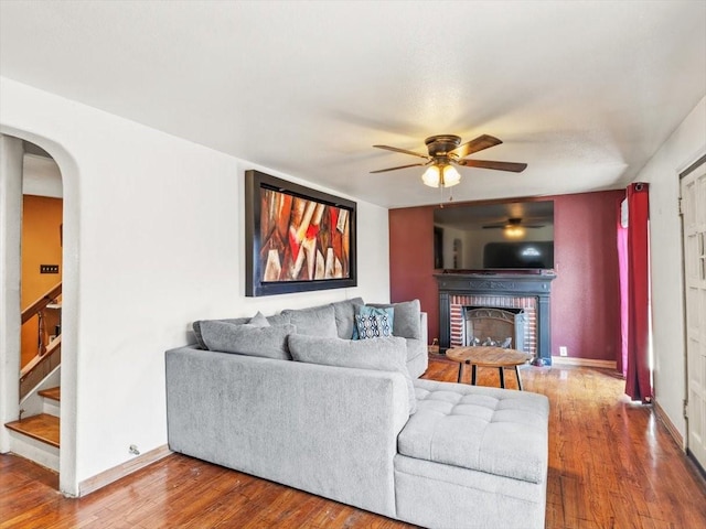 living room featuring hardwood / wood-style floors, a fireplace, and ceiling fan