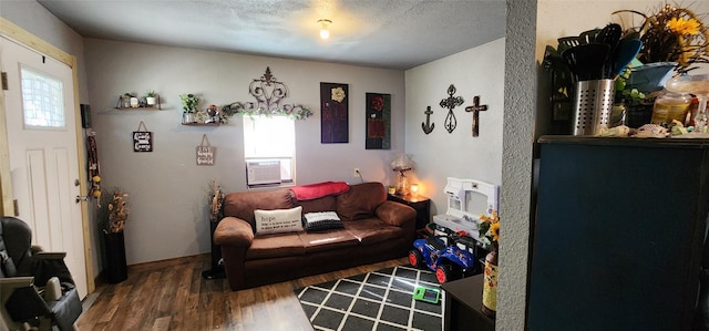 living room featuring cooling unit, hardwood / wood-style floors, and a textured ceiling