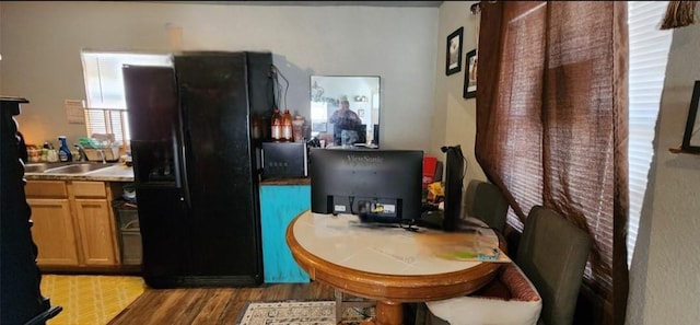 kitchen featuring sink, dark wood-type flooring, and black refrigerator with ice dispenser