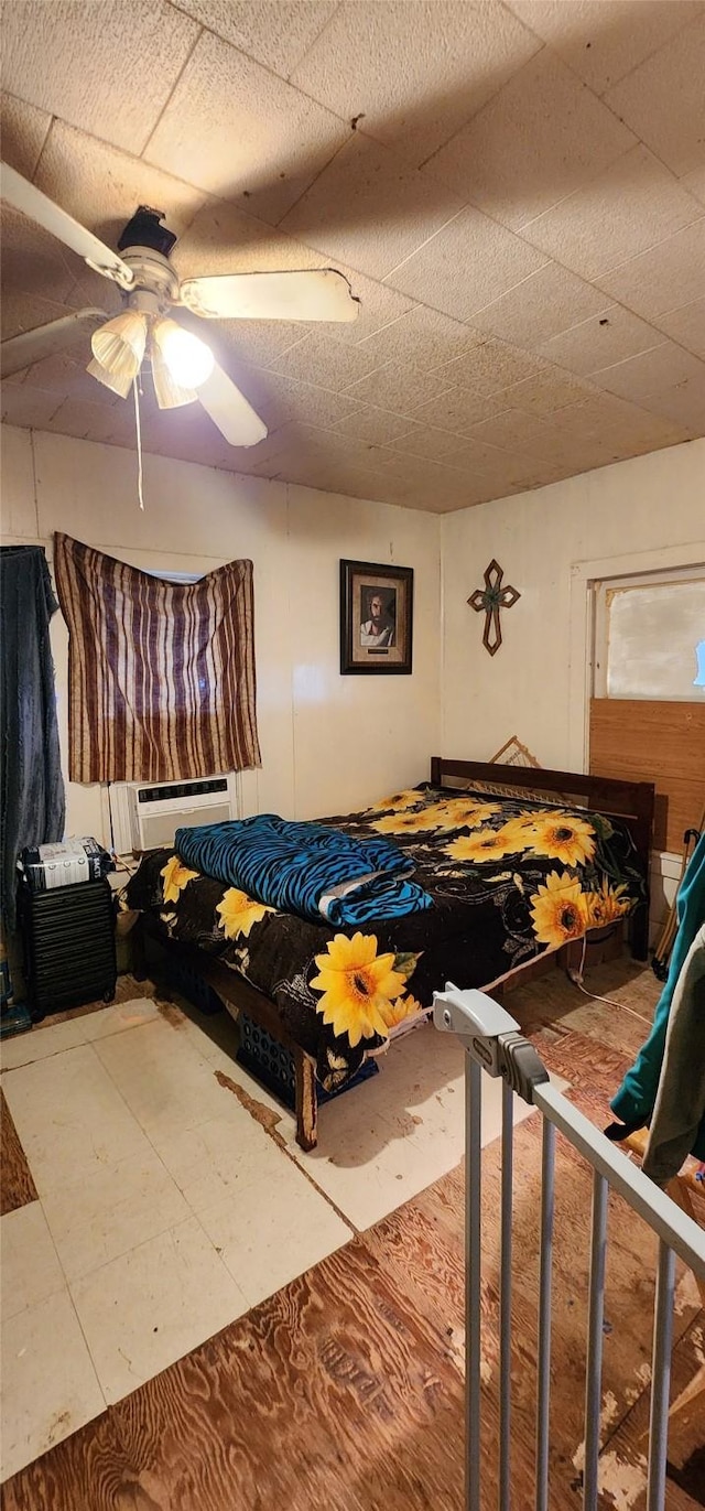 tiled bedroom with a wall mounted AC and ceiling fan