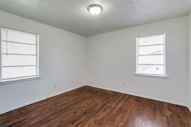 unfurnished room with dark wood-type flooring