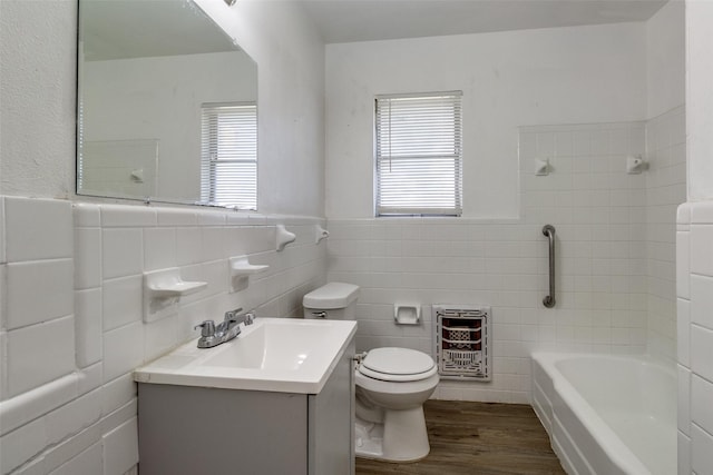 bathroom with hardwood / wood-style flooring, a wealth of natural light, heating unit, and vanity