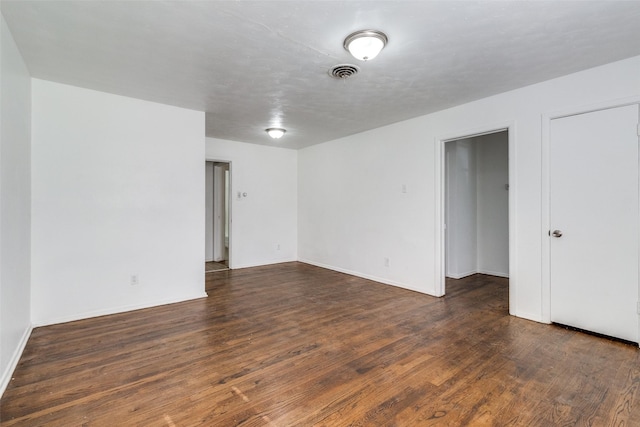 spare room with dark wood-type flooring