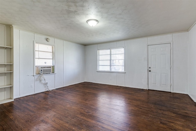 interior space featuring cooling unit, plenty of natural light, dark hardwood / wood-style floors, and a textured ceiling