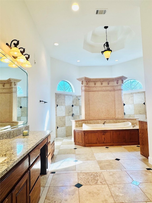 bathroom featuring plenty of natural light, shower with separate bathtub, a raised ceiling, and vanity