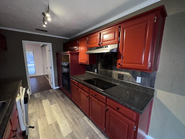 kitchen with tasteful backsplash, rail lighting, ornamental molding, black appliances, and light hardwood / wood-style flooring