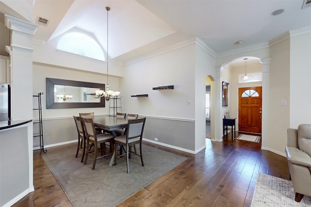 dining space featuring a healthy amount of sunlight, dark hardwood / wood-style flooring, a chandelier, and ornate columns