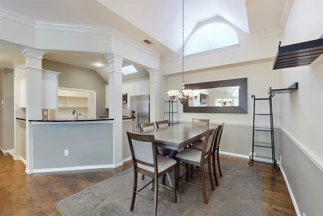 dining space with ornate columns, crown molding, vaulted ceiling, dark hardwood / wood-style flooring, and a notable chandelier