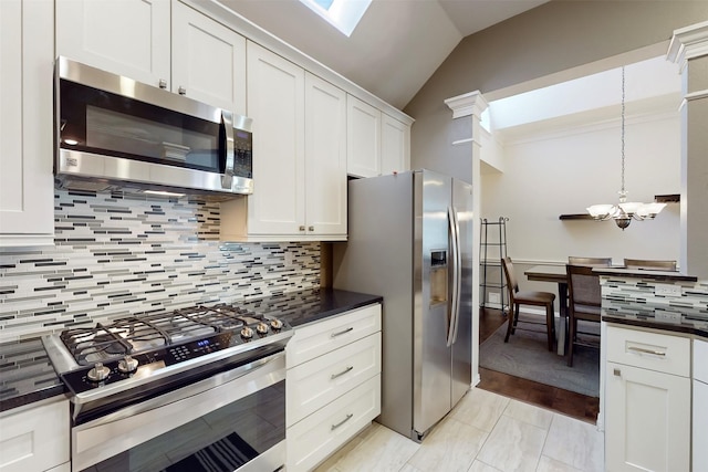 kitchen featuring pendant lighting, lofted ceiling, appliances with stainless steel finishes, and white cabinets