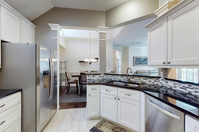 kitchen with sink, white cabinetry, tasteful backsplash, pendant lighting, and stainless steel appliances