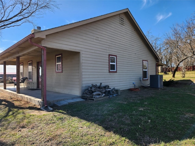 view of property exterior with central AC unit, a lawn, and a patio area