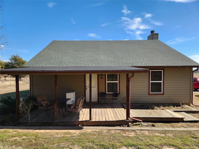 rear view of property featuring a wooden deck