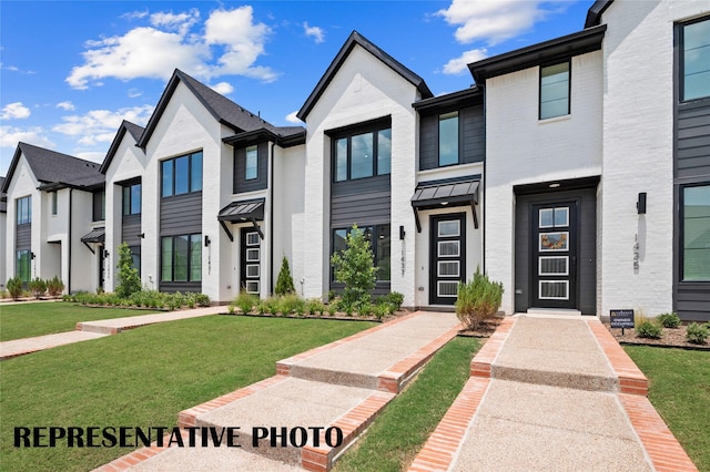 townhome / multi-family property featuring a front lawn