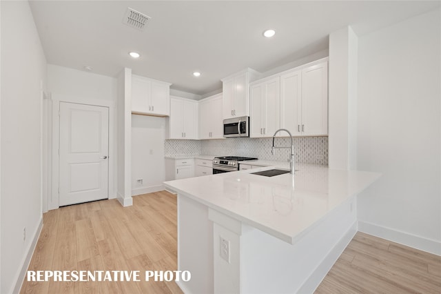 kitchen with sink, white cabinets, and appliances with stainless steel finishes