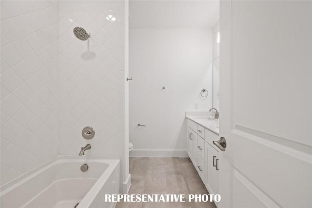 full bathroom featuring tiled shower / bath, vanity, and toilet