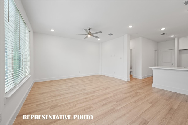 unfurnished living room with ceiling fan and light hardwood / wood-style flooring