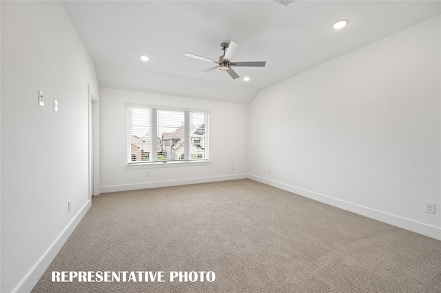 carpeted empty room with lofted ceiling and ceiling fan