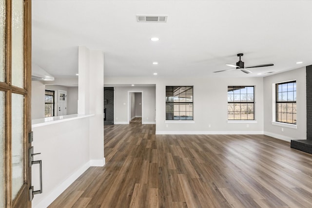 unfurnished living room featuring ceiling fan, wood-type flooring, and a brick fireplace