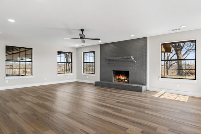 unfurnished living room featuring hardwood / wood-style flooring, a fireplace, and ceiling fan