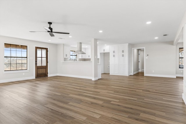 unfurnished living room featuring ceiling fan, dark hardwood / wood-style flooring, and sink