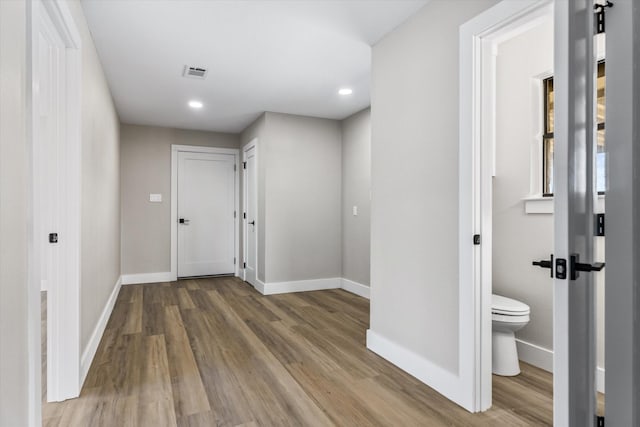 hallway with hardwood / wood-style flooring