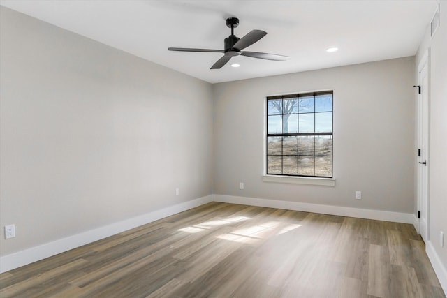 spare room with hardwood / wood-style floors and ceiling fan