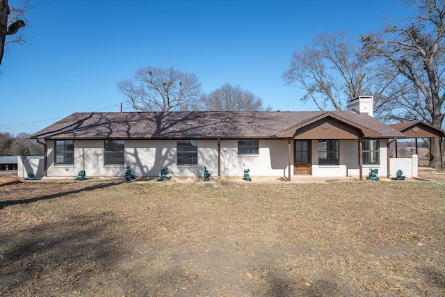 rear view of property featuring covered porch and a lawn