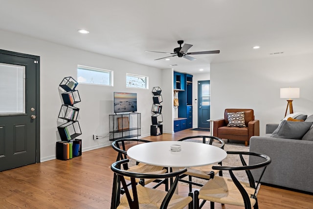 dining space with ceiling fan and light wood-type flooring