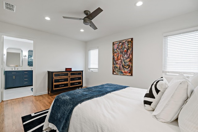 bedroom with ceiling fan, ensuite bathroom, sink, and wood-type flooring